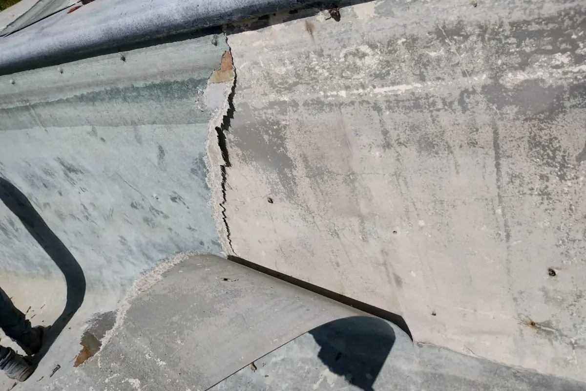 Muro de la piscina con el revestimiento antiguo agrietado y desprendido