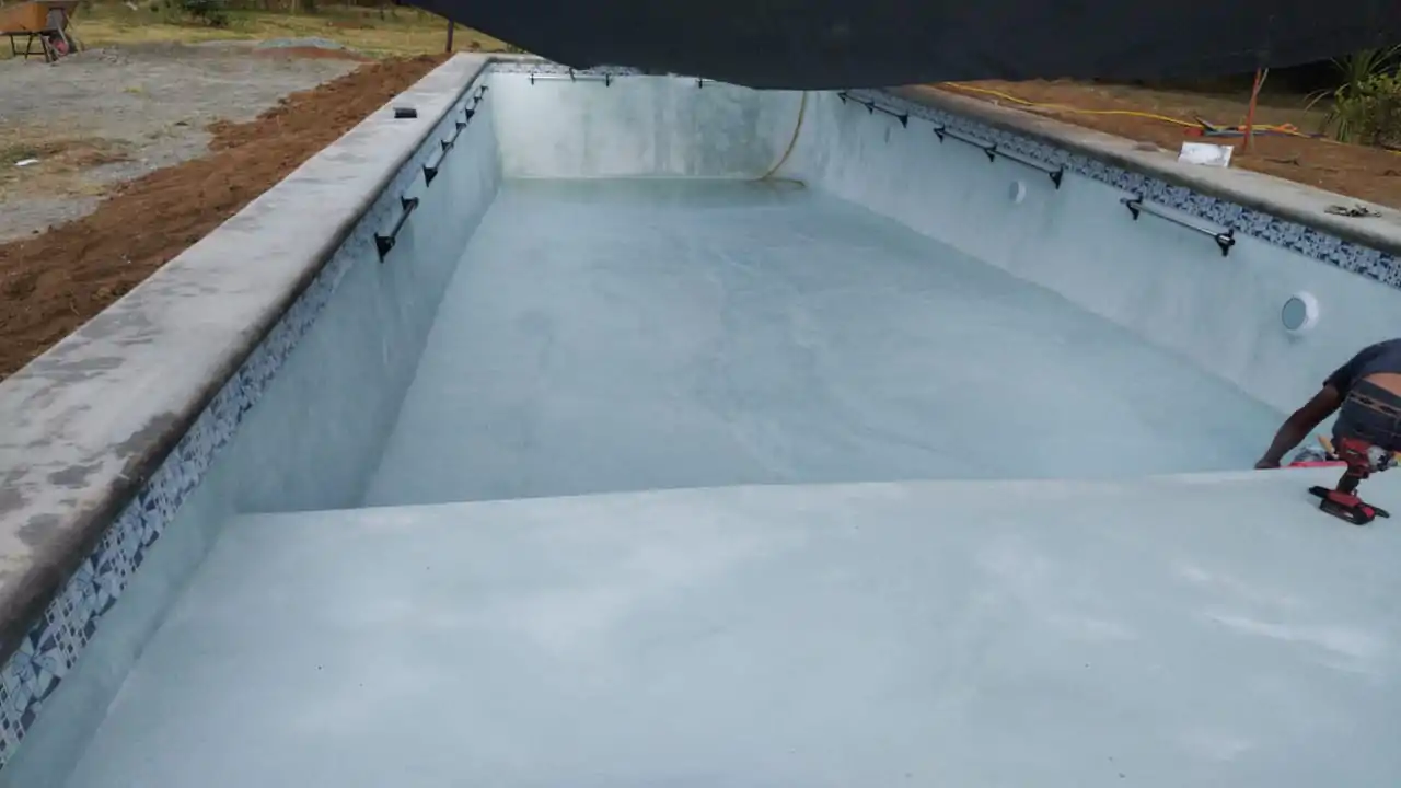 Piscina con revestimiento aplicado y línea de mosaico instalada